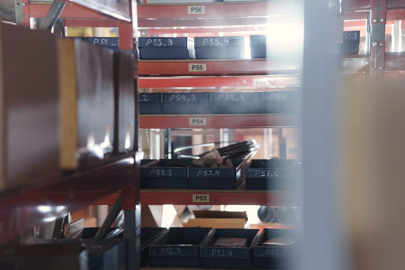 Red steel shelving with labeled parts bins