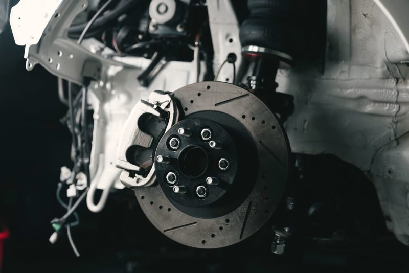 A brake caliper and rotor on a car with the wheel off