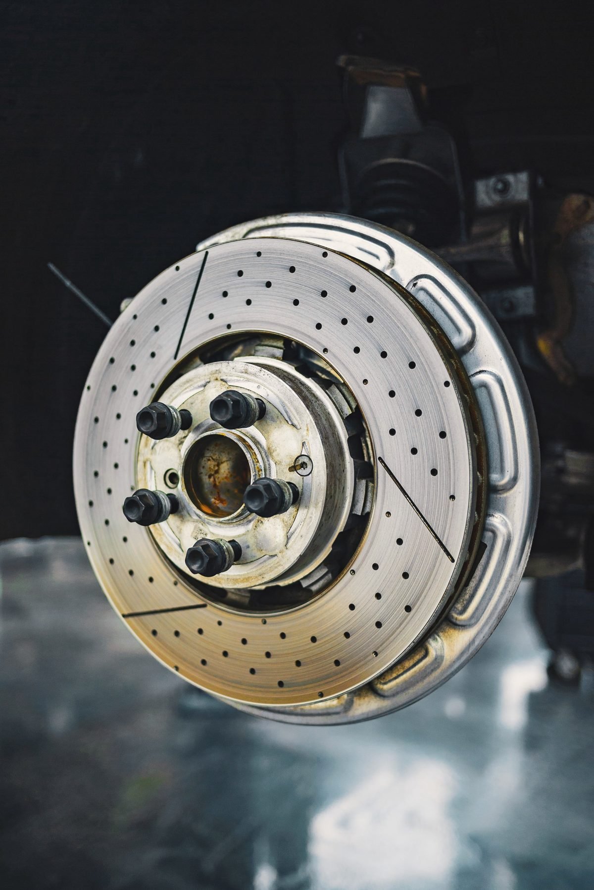 A drilled and slotted brake rotor mounted on a hub