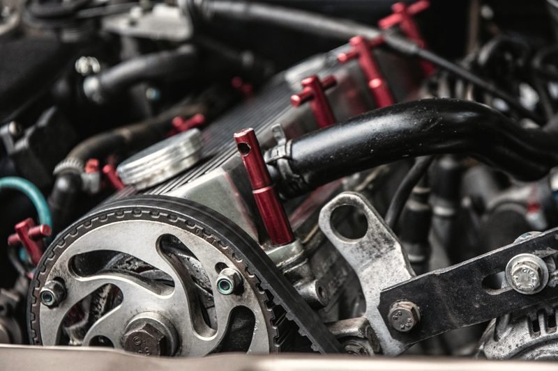The front of an engine with pulleys, hoses and the timing belt exposed
